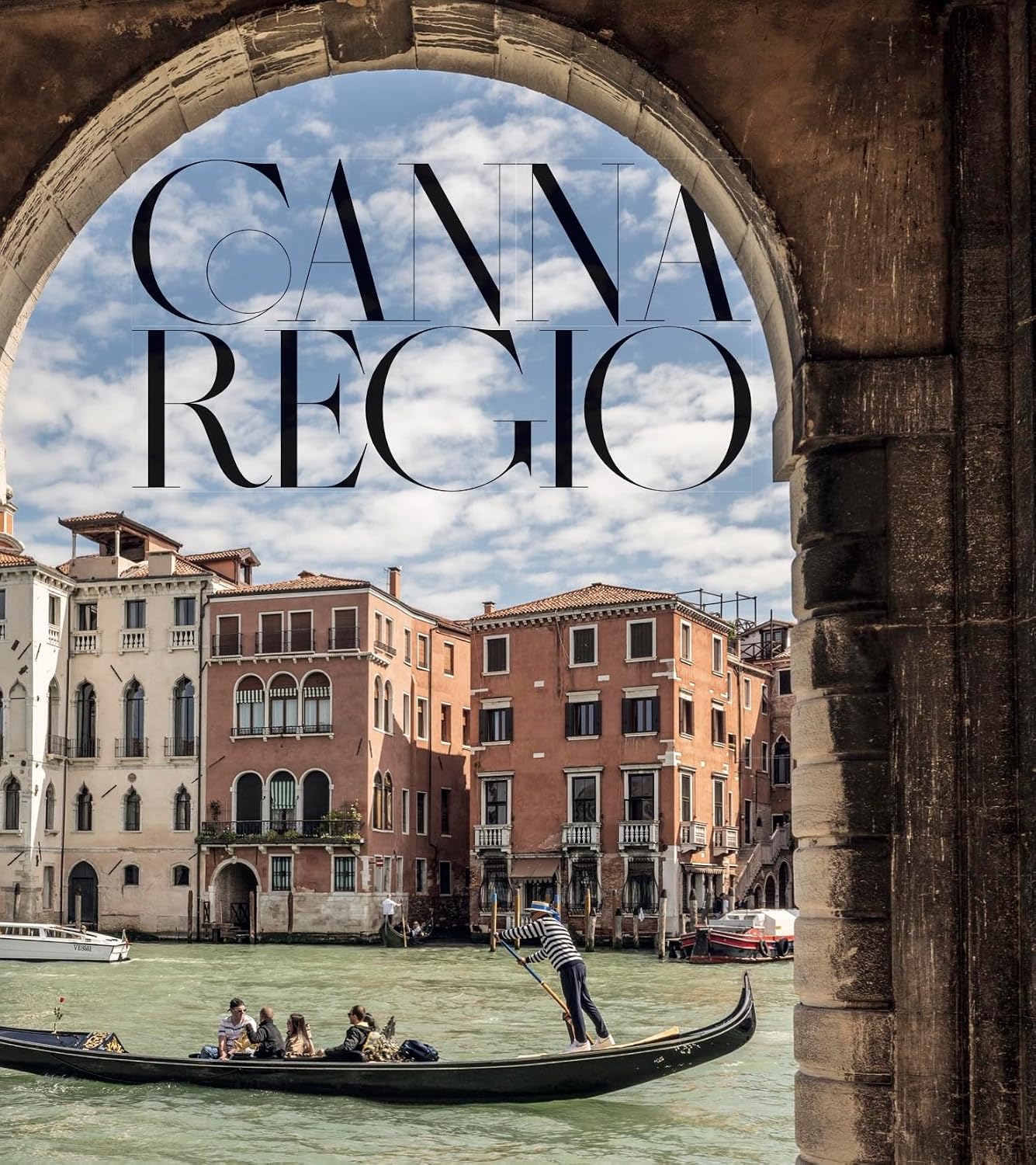 A scenic photograph of Venice viewed through a stone arch, with a gondola on the canal and large overlaid text reading 'CANNA REGIO'.