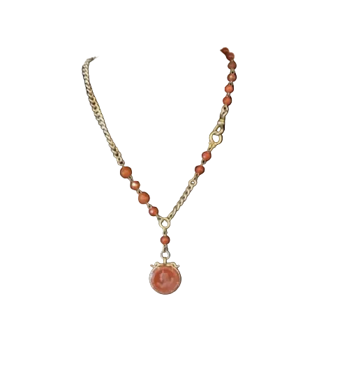 Necklace with brown beads and a pendant on a black mannequin bust against a plain background