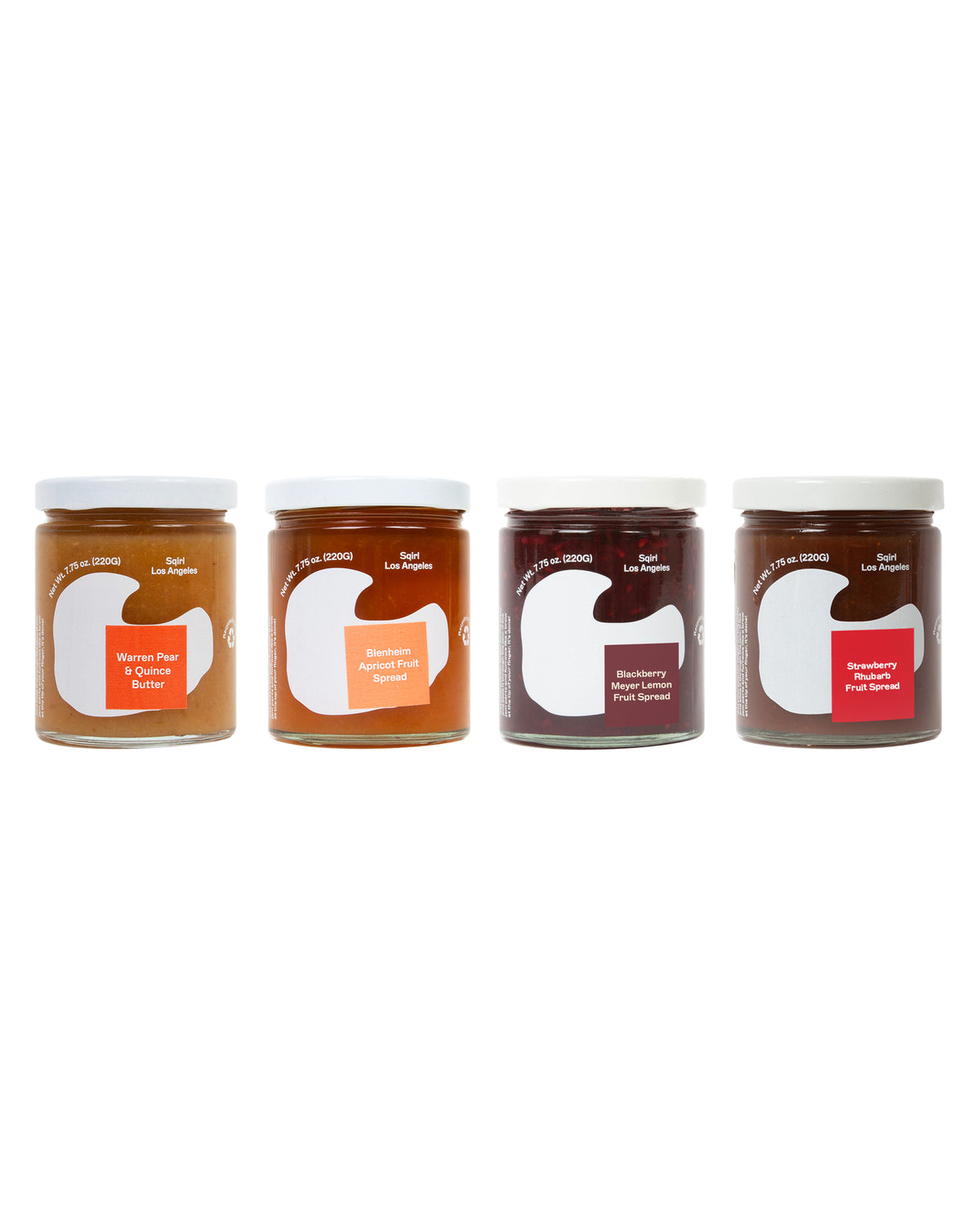 Four glass jars of fruit preserves lined up on a white background, featuring white lids and white labels with orange, peach, and red accents.