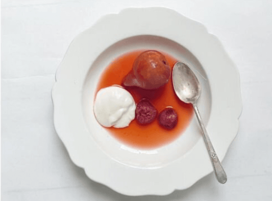 Bella Cucina Poached Pears with Raspberries and Preserved Lemon Cream served in a white bowl