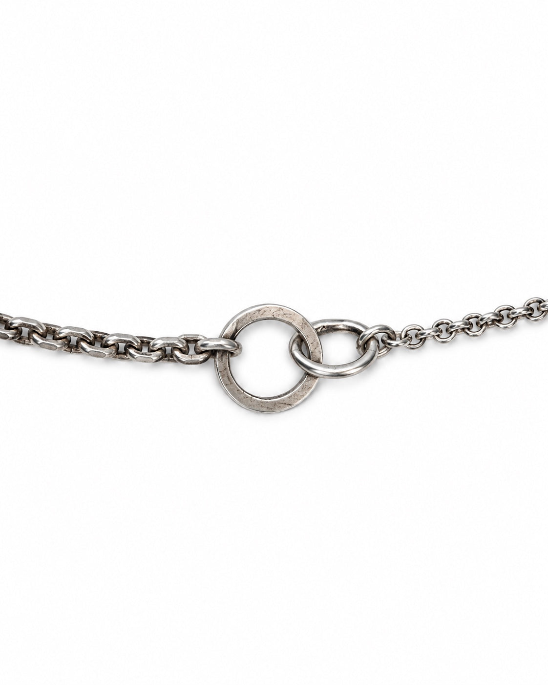 A close-up of a silver-toned metal chain bracelet featuring a textured circular ring clasp on a plain white background.