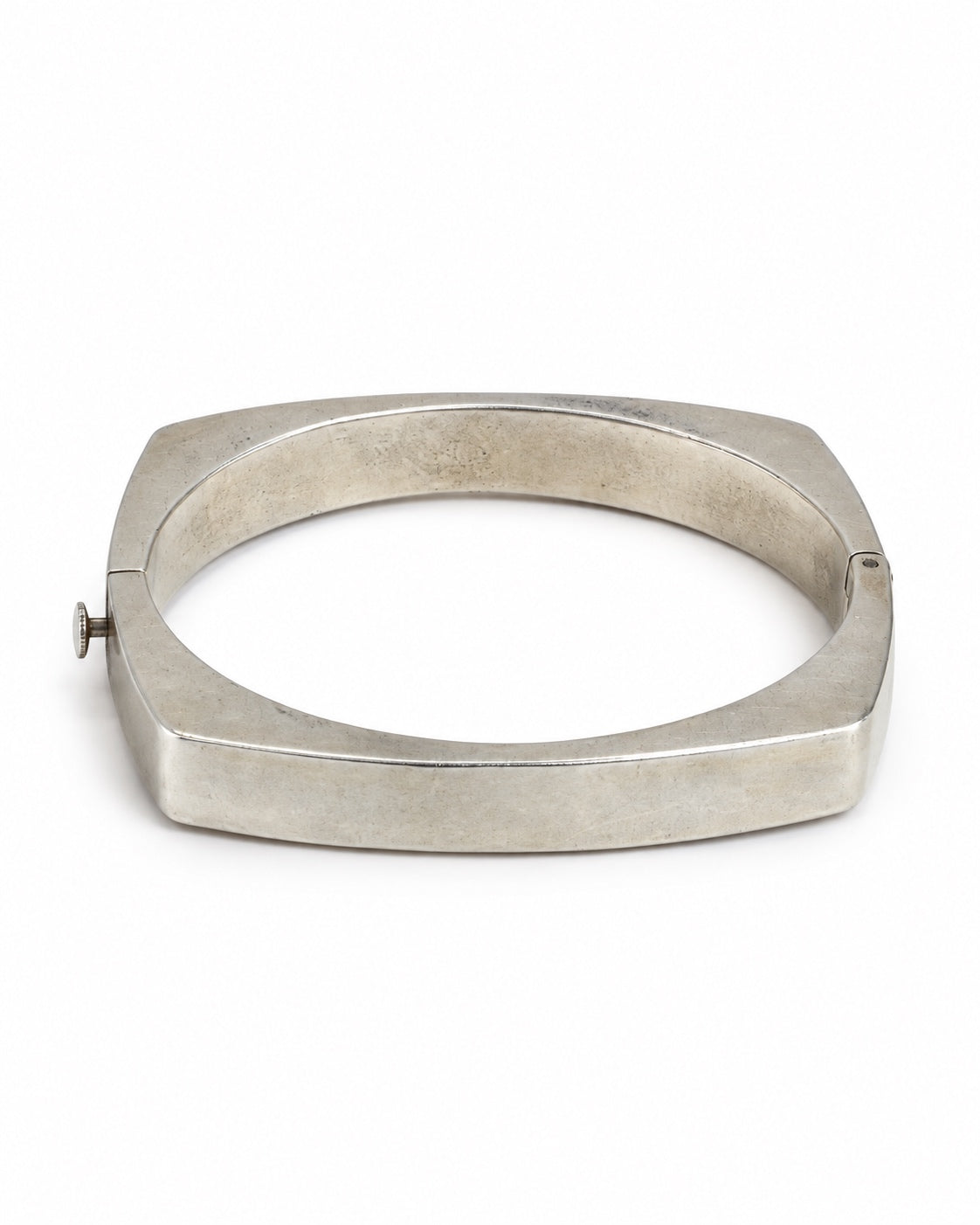 A wide, chunky silver-toned metal bangle bracelet with a flat, geometric square-like profile and a small side clasp, shown on a plain white background.