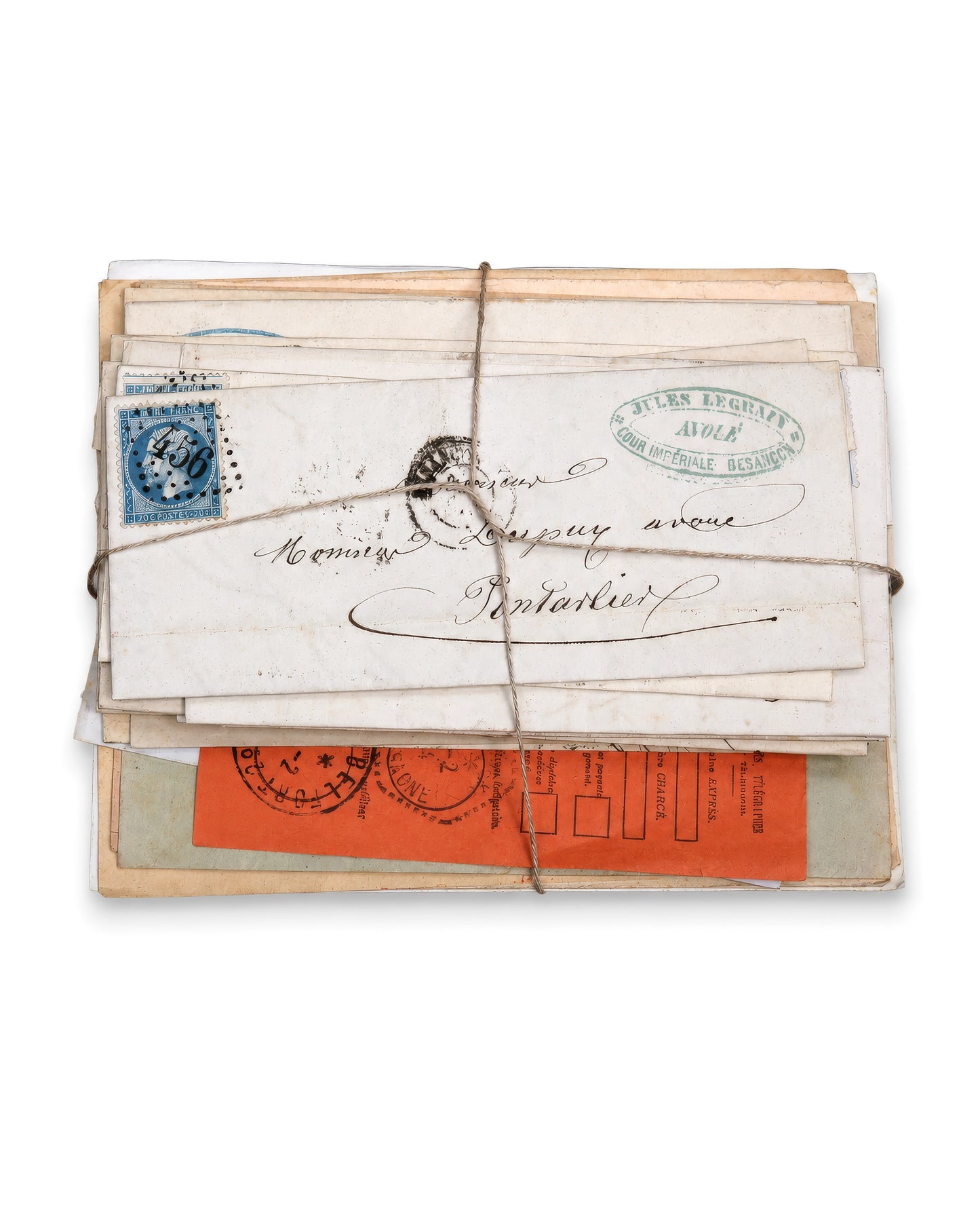 A vintage bundle of old letters and postcards tied together with twine, featuring an orange-red stamp, a blue postage stamp, and handwritten addresses on aged paper. Bundle No. 1 of six one-of-a-kind vintage letter bundles at Bella Cucina.