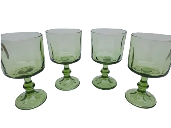 Set of four green glass goblets on a white background