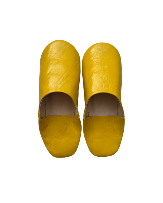 A pair of handcrafted Moroccan slippers in vibrant yellow leather, designed for comfort and style