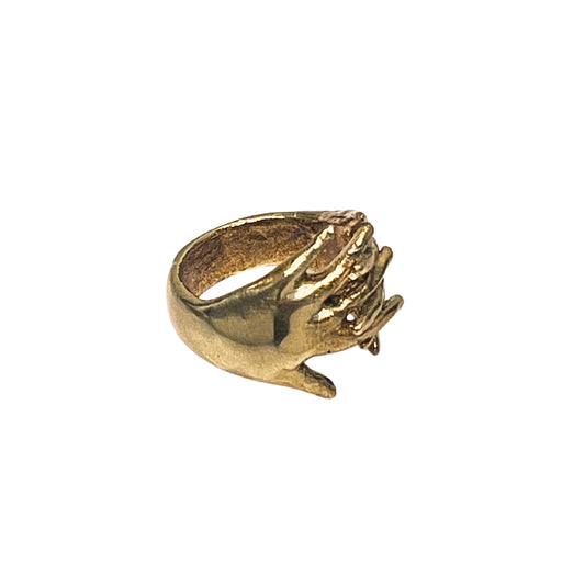 Gold ring with a hand design on a white background